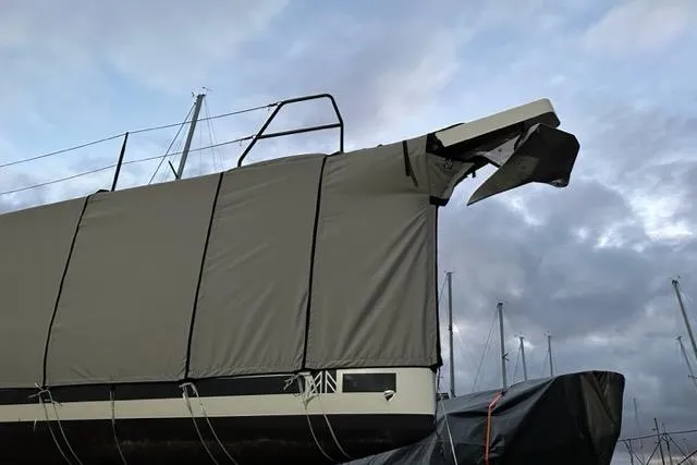 Slide: The Image of 2022 Dufour 530 sailboat covered, docked under cloudy sky. - 23