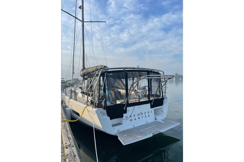 Slide: The Image of 2022 Dufour 530 sailboat docked, featuring "Dreamers Wanted" text on the stern. - 25