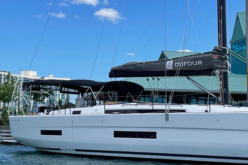 Slide: The Image of 2022 Dufour 530 sailboat docked at marina under clear blue sky. - 26