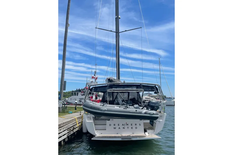 Slide: The Image of 2022 Dufour 530 yacht docked, featuring sleek design and "Dreamers Wanted" sign. - 27