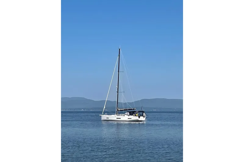 Slide: The Image of Sailing yacht Dufour 530 (2022) on calm water with mountainous backdrop. - 29