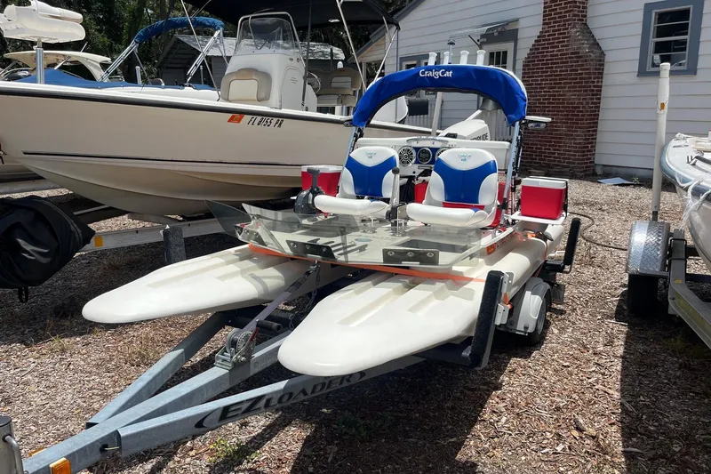 Slide: The Image of 2016 CraigCat E2 Elite catamaran on trailer, parked beside other boats. - 4