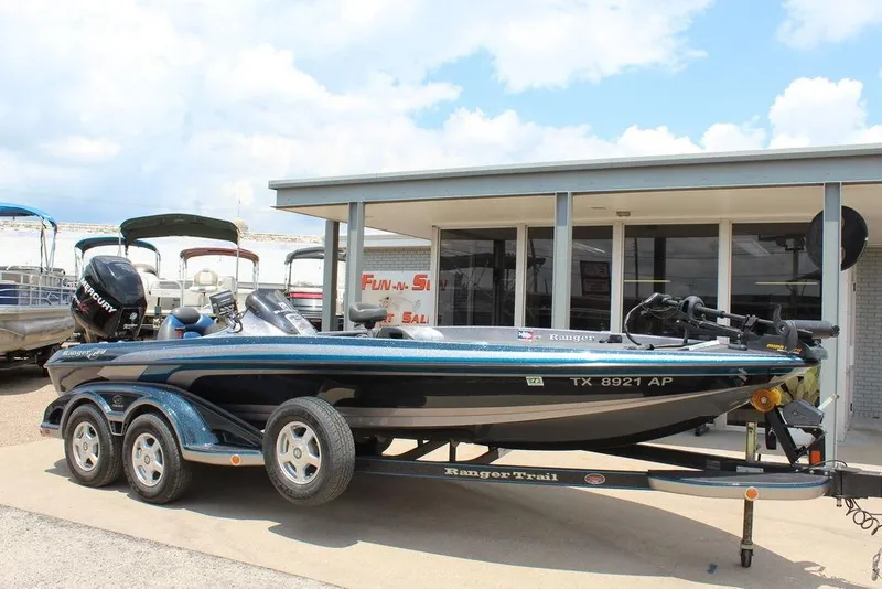 The Image of 2008 Ranger Z21 boat on trailer, parked outside a dealership under a cloudy sky. - 1