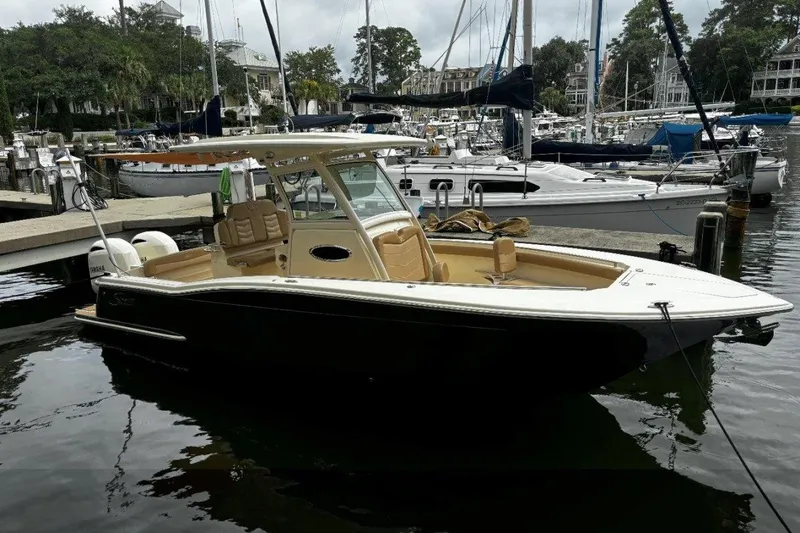 The Image of 2019 Scout 255 LXF boat docked in a marina, surrounded by other vessels. - 0