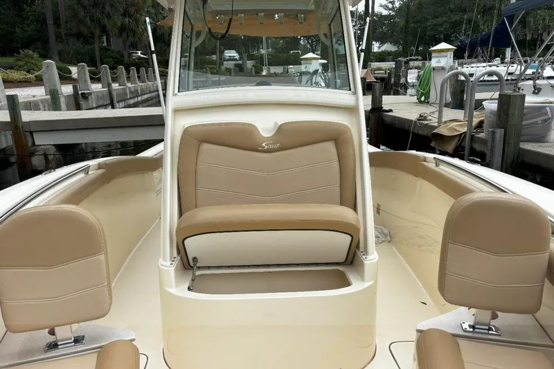 Slide: The Image of 2019 Scout 255 LXF boat interior with tan seating and helm station. - 2