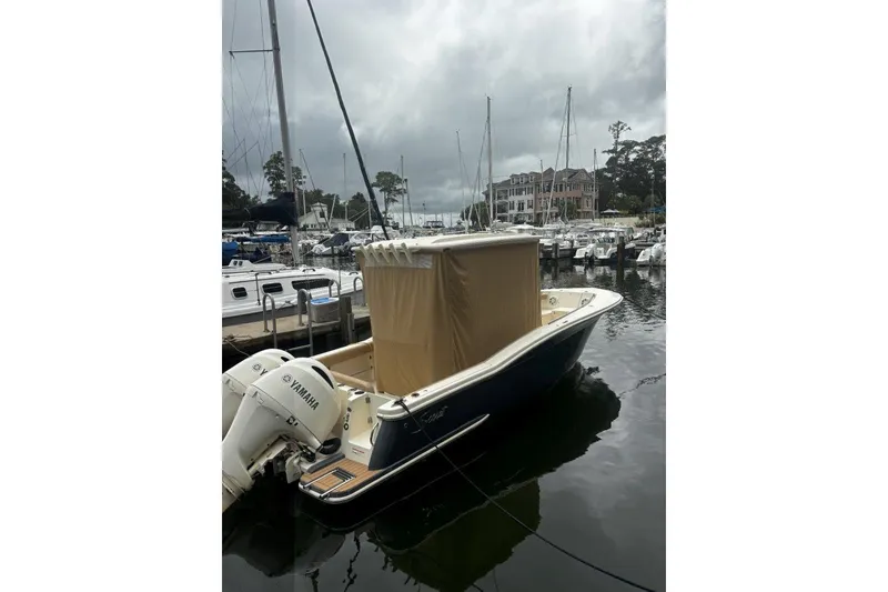 Slide: The Image of 2019 Scout 255 LXF boat docked with Yamaha engines, overcast sky. - 4
