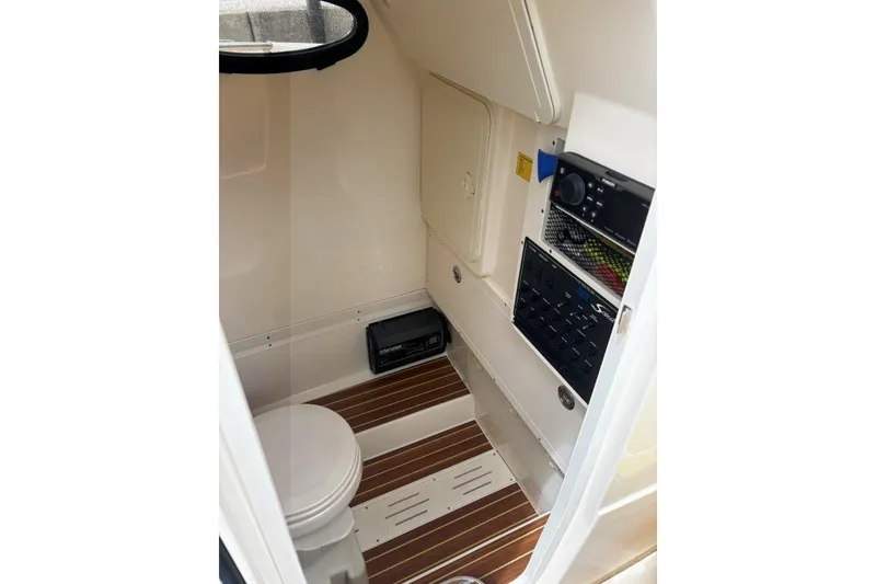 Slide: The Image of 2019 Scout 255 LXF boat interior with toilet and control panel. - 9