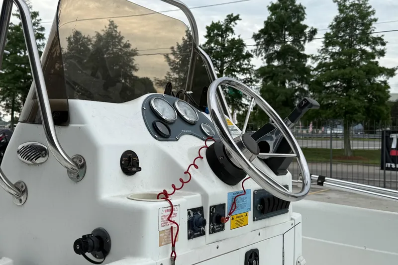 Slide: The Image of Console of a 2002 Fishmaster 19 boat with steering wheel and gauges. - 11