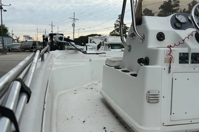 Slide: The Image of 2002 Fishmaster 19 boat interior with control panel and railing, parked outdoors. - 12