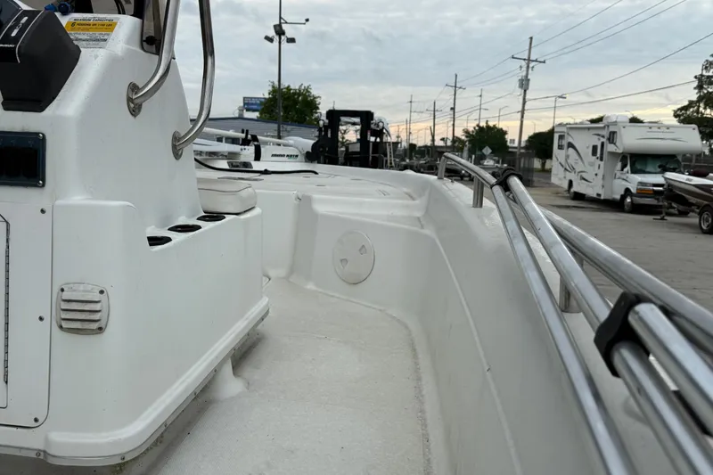 Slide: The Image of 2002 Fishmaster 19 boat interior with railing and control panel, parked near RVs and trailers. - 14