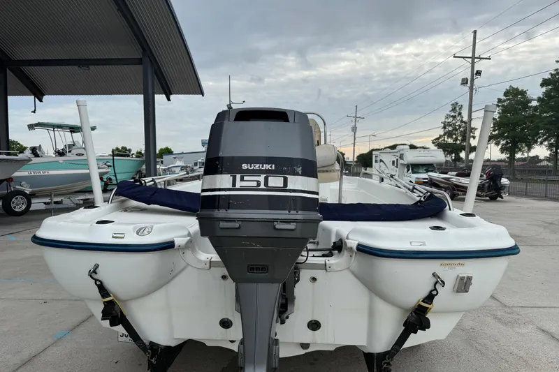 Slide: The Image of 2002 Fishmaster 19 boat with Suzuki 150 outboard motor, parked outdoors. - 5