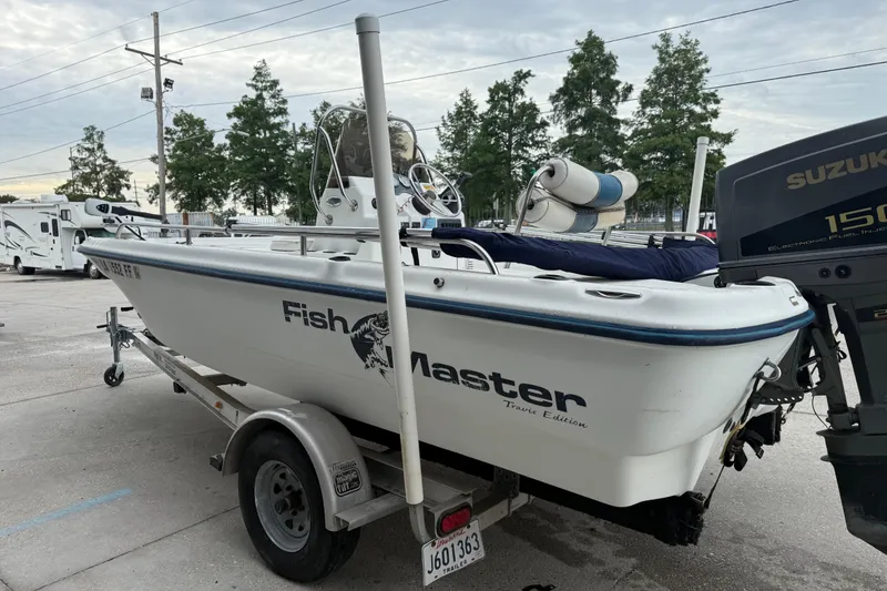 Slide: The Image of 2002 Fishmaster 19 boat on trailer with Suzuki 150 engine, parked outdoors. - 6