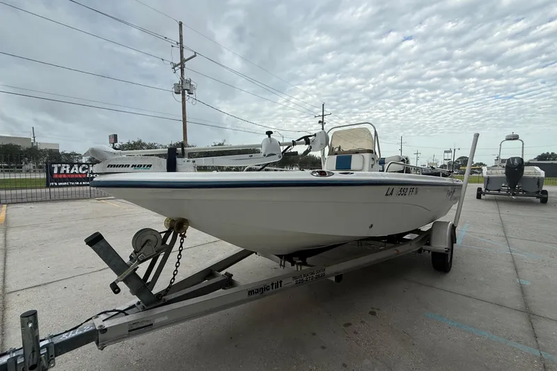 Slide: The Image of 2002 Fishmaster 19 boat on trailer, parked outdoors under cloudy sky. - 8