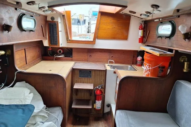 Slide: The Image of Interior of a 1976 Cape Dory 30 sailboat with wooden cabinetry and seating. - 12