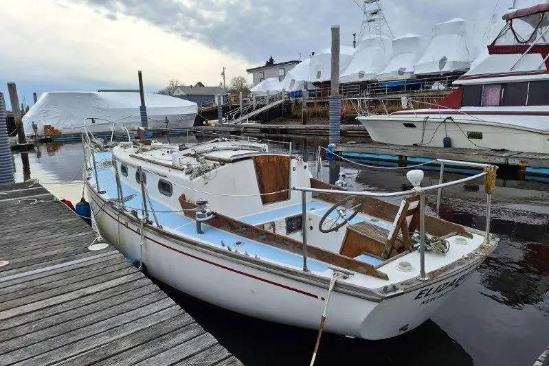 Slide: The Image of 1976 Cape Dory 30 sailboat docked at a marina, overcast sky. - 2