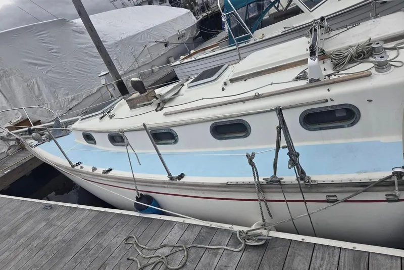 Slide: The Image of 1976 Cape Dory 30 sailboat docked, featuring classic design and nautical ropes. - 3
