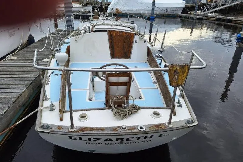 Slide: The Image of 1976 Cape Dory 30 sailboat docked, featuring wooden accents and a blue deck. - 4