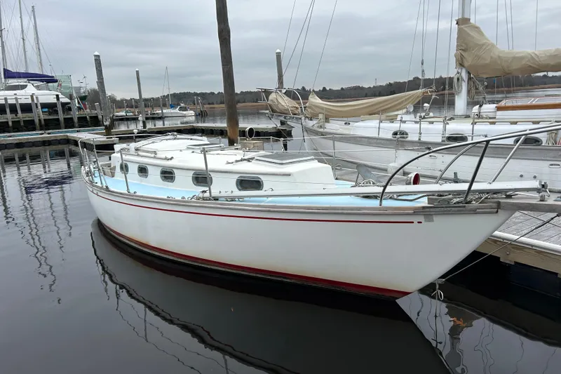 Slide: The Image of 1976 Cape Dory 30 sailboat docked at a marina, featuring classic design and white hull. - 6