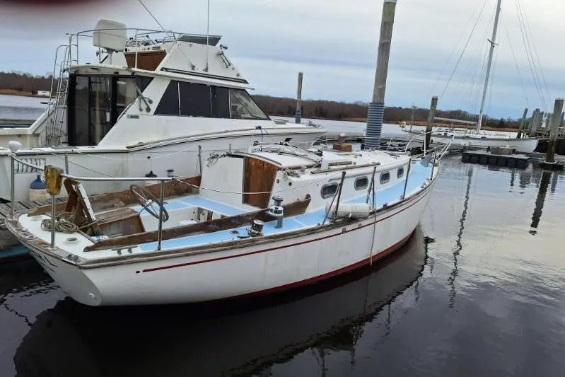 Slide: The Image of 1976 Cape Dory 30 sailboat docked beside a larger motor yacht. - 8