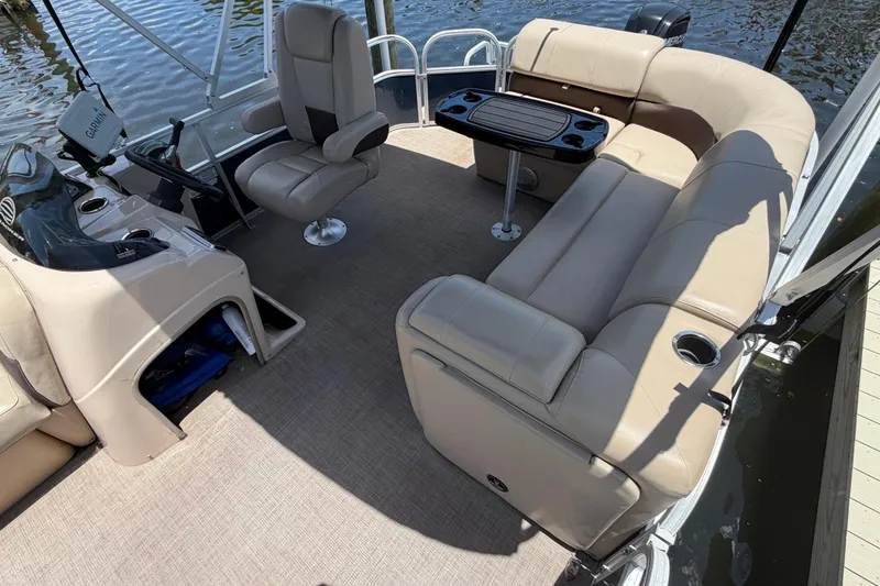 Slide: The Image of 2019 Sun Tracker Party Barge 20 DLX interior with beige seating and steering console. - 10