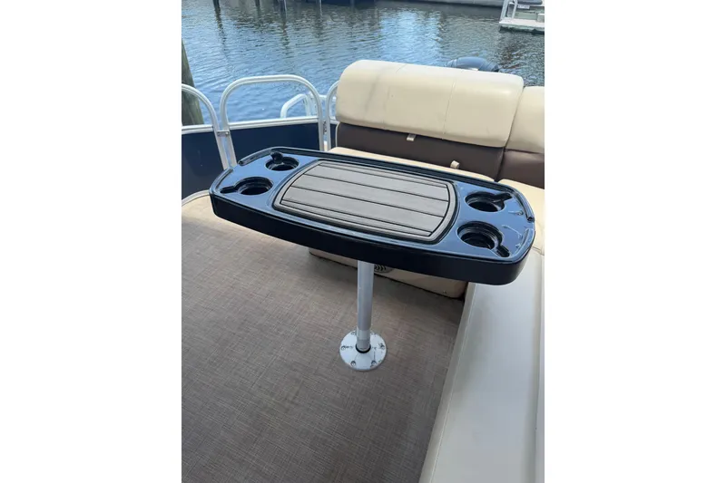Slide: The Image of 2019 Sun Tracker Party Barge 20 DLX interior with table and cup holders. - 18