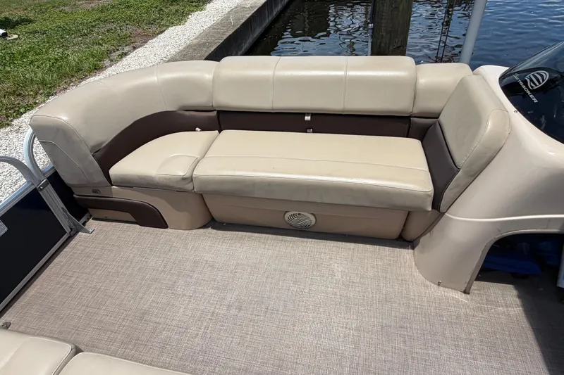Slide: The Image of 2019 Sun Tracker Party Barge 20 DLX pontoon boat seating area by the water. - 19