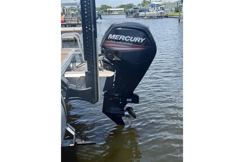 Slide: The Image of 2019 Sun Tracker Party Barge 20 DLX with Mercury outboard motor on water. - 2