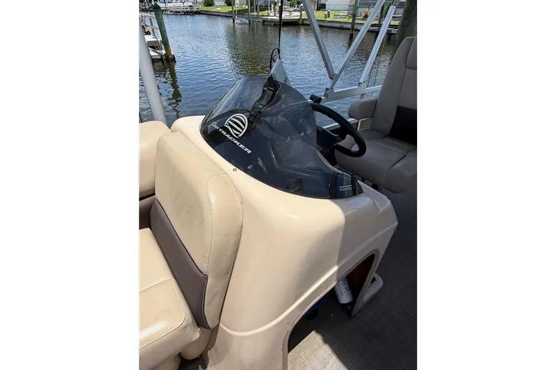Slide: The Image of 2019 Sun Tracker Party Barge 20 DLX helm with steering wheel, docked by water. - 21