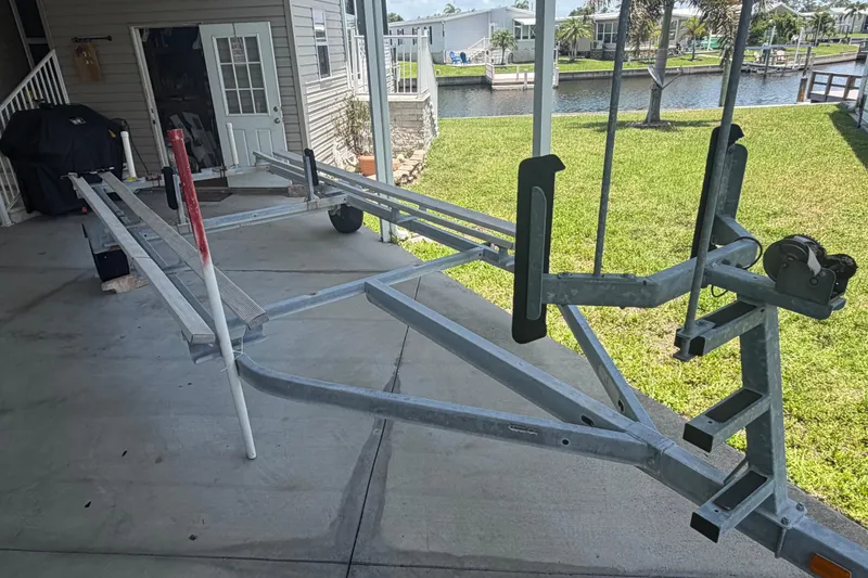Slide: The Image of Empty boat trailer for 2019 Sun Tracker Party Barge 20 DLX, parked on concrete driveway. - 24