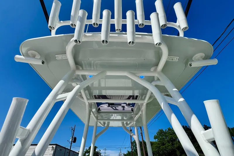 Slide: The Image of 2023 Barker Boatworks 26 Open, view of rod holders and T-top against blue sky. - 12