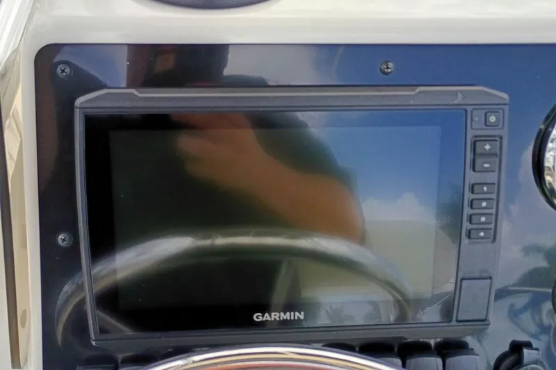 Slide: The Image of Garmin display on 2023 Bulls Bay 2200 boat dashboard, reflecting sky and surroundings. - 13