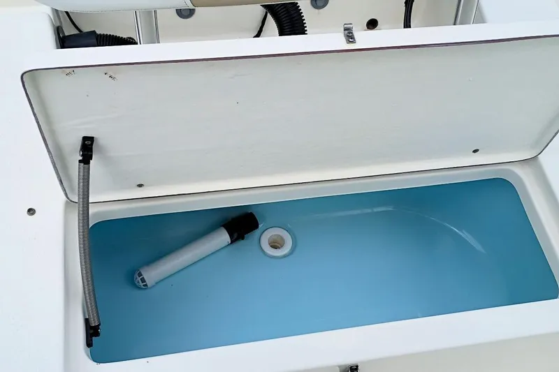 Slide: The Image of Open storage compartment on 2023 Bulls Bay 2200 boat, featuring a blue interior. - 36