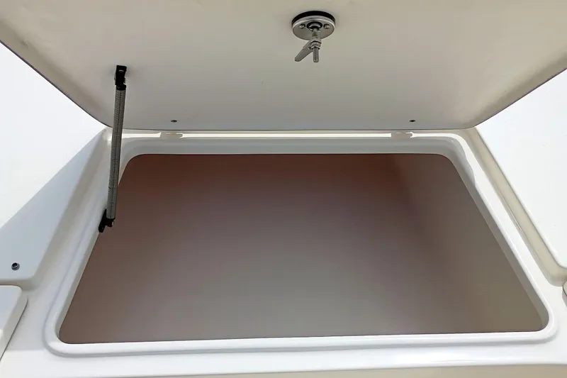 Slide: The Image of Open storage compartment on 2023 Bulls Bay 2200 boat, featuring secure latch and spring support. - 41