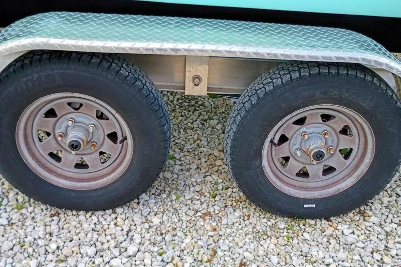 Slide: The Image of Trailer wheels of a 2023 Bulls Bay 2200 boat on gravel surface. - 47