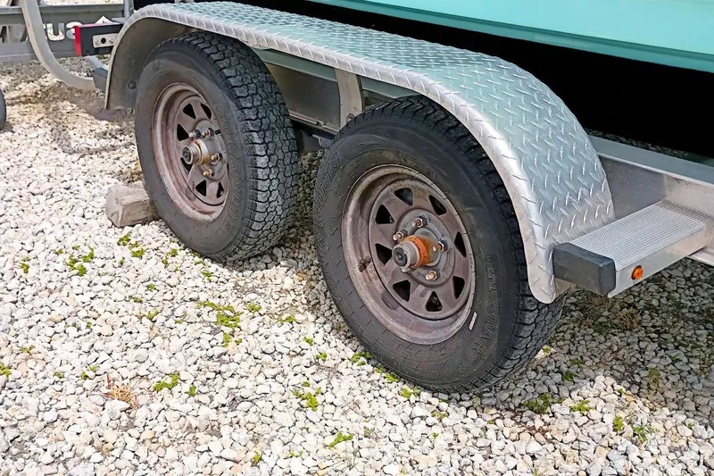 Slide: The Image of Trailer wheels of a 2023 Bulls Bay 2200 boat on gravel surface. - 49