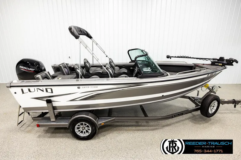 The Image of 2023 Lund 1875 Tyee fishing boat on trailer, featuring Mercury outboard motor. - 1