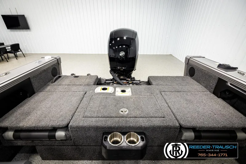 Slide: The Image of 2023 Lund 1875 Tyee boat interior with motor, carpeted deck, and storage compartments. - 20