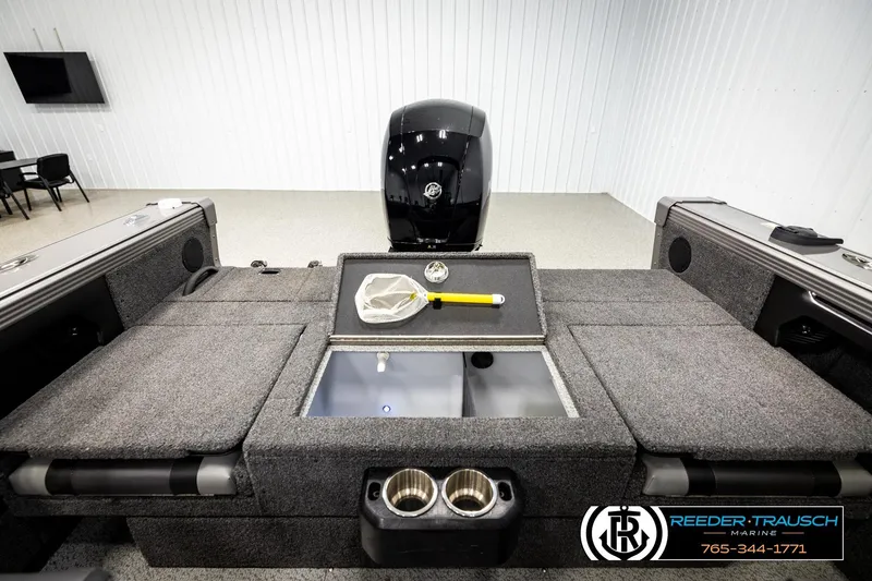 Slide: The Image of 2023 Lund 1875 Tyee boat interior with storage compartments and motor in showroom. - 21