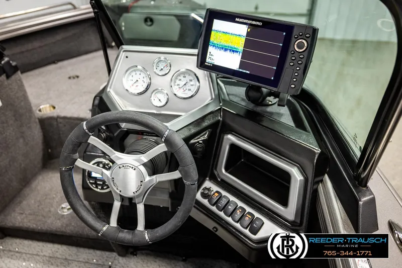 Slide: The Image of 2023 Lund 1875 Tyee boat dashboard with steering wheel and Humminbird fish finder display. - 35