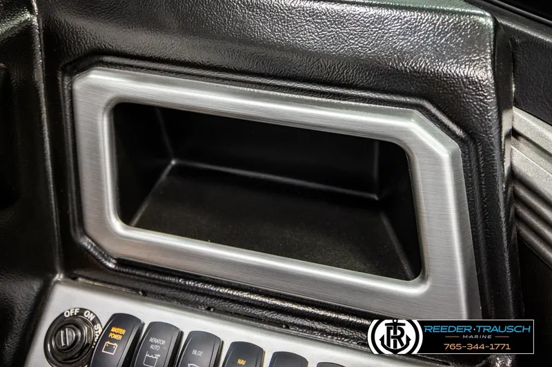Slide: The Image of 2023 Lund 1875 Tyee dashboard with control switches and storage compartment. - 41