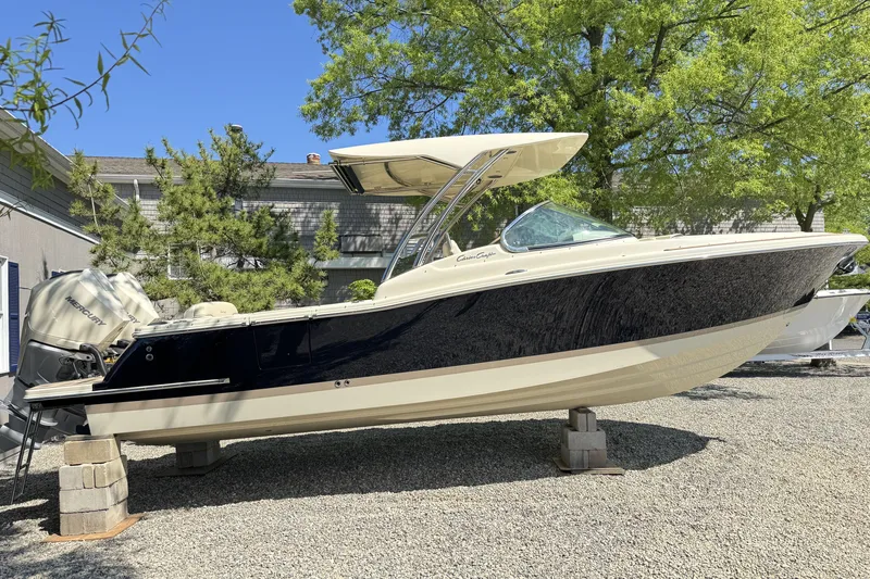 The Image of 2025 Chris-Craft Calypso 28 boat on display, outdoors, with trees in the background. - 0
