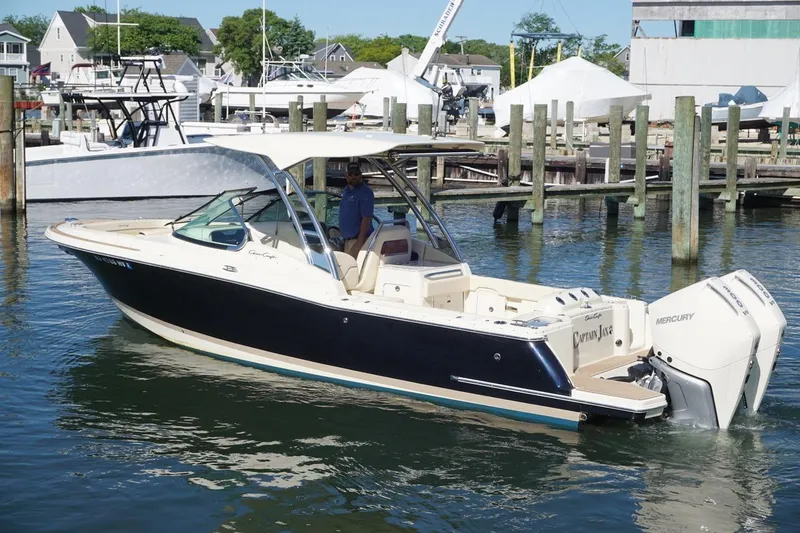 Slide: The Image of 2025 Chris-Craft Calypso 28 boat docked in marina, featuring sleek design and Mercury outboard engines. - 1