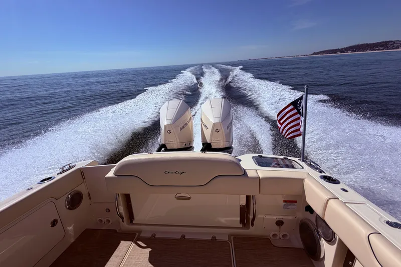 Slide: The Image of 2025 Chris Craft 28 Calypso cruising on open water with American flag. - 12