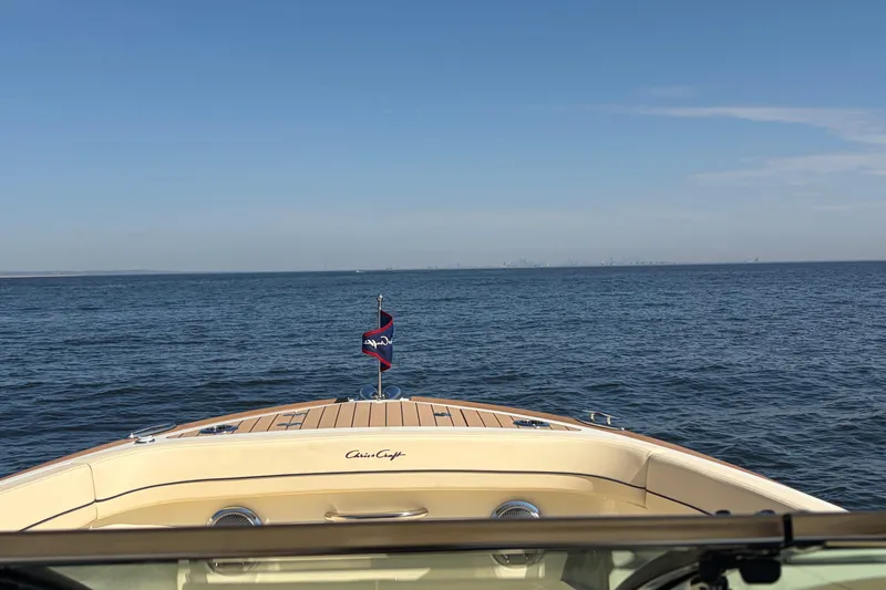 Slide: The Image of 2025 Chris Craft 28 Calypso boat cruising on open water under clear blue skies. - 20