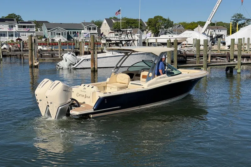 Slide: The Image of 2025 Chris-Craft Calypso 28 boat docked in a marina, featuring dual Mercury engines. - 4