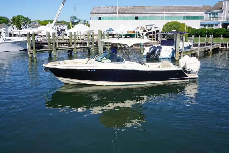 Slide: The Image of 2025 Chris-Craft Calypso 28 boat docked in a marina, featuring sleek design and dual engines. - 5