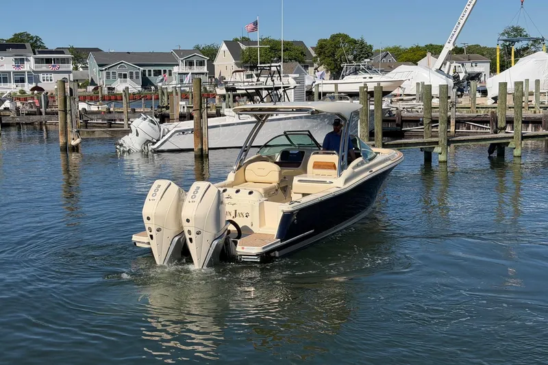 Slide: The Image of 2025 Chris-Craft Calypso 28 boat docked in a marina with dual outboard engines. - 6
