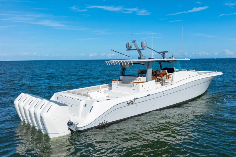 Slide: The Image of 2027 HCB 65 Estrella luxury boat cruising on open water under clear blue skies. - 2