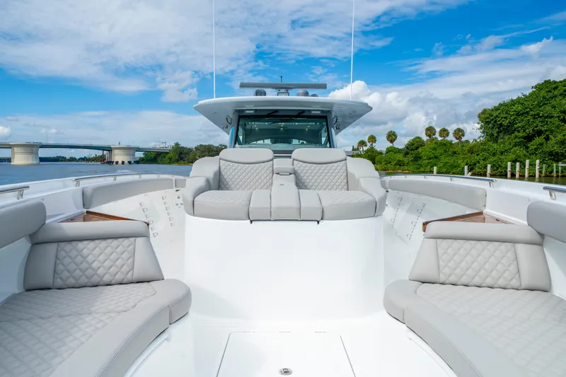Slide: The Image of Luxurious 2027 HCB 65 Estrella yacht with plush seating, cruising near a scenic bridge. - 28