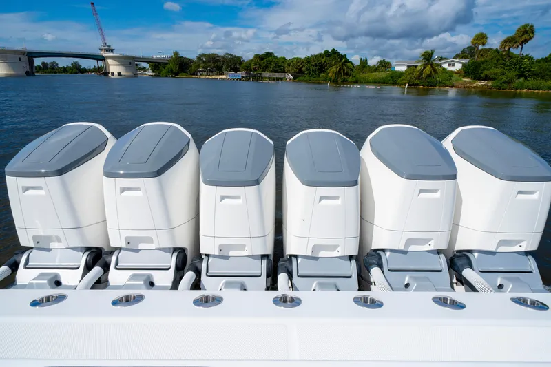 Slide: The Image of Five powerful outboard motors on a 2027 HCB 65 Estrella boat, with scenic waterway backdrop. - 34